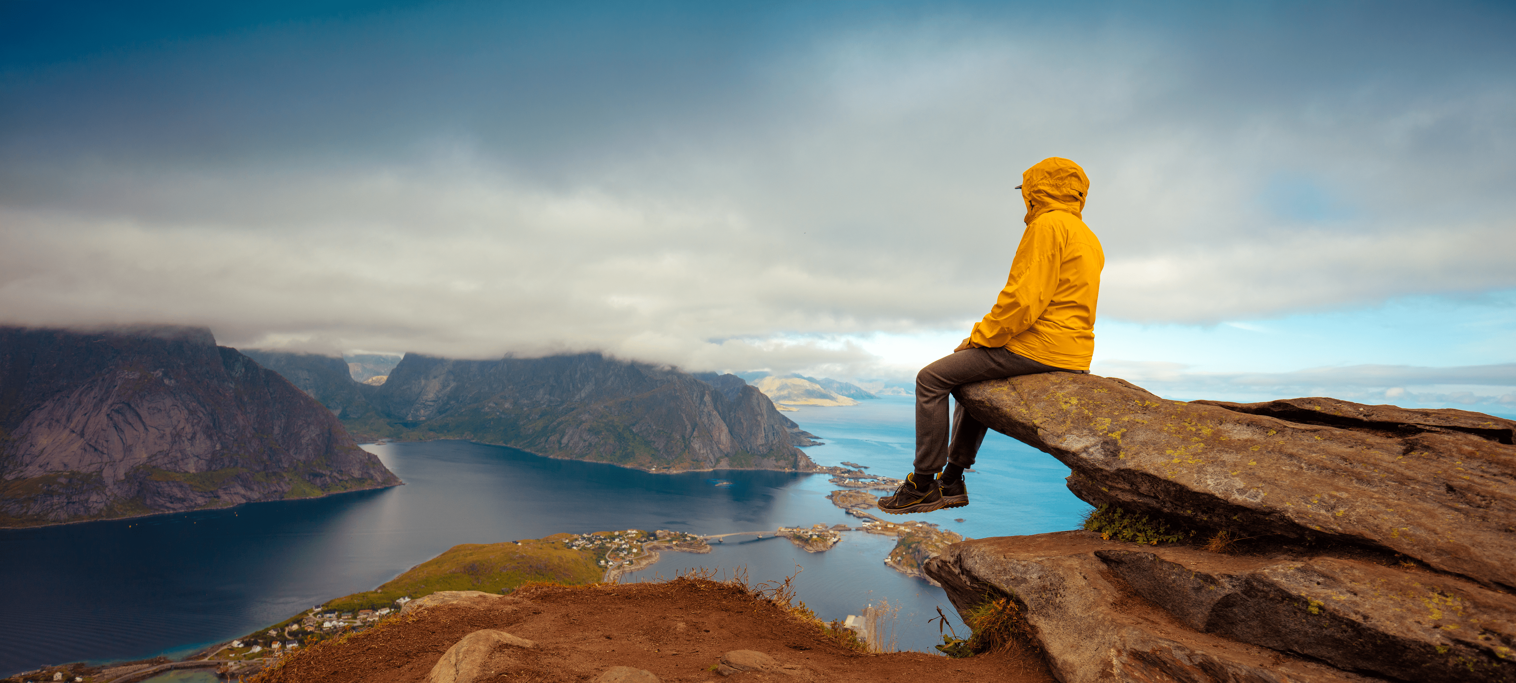 male-tourist-sitting-on-the-cliff-beautiful-mountain